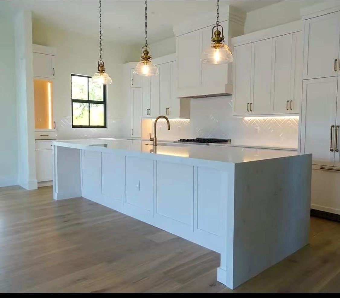 Freshly painted white kitchen cabinets and island by BMG Style Painting Company